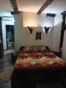 a bedroom with a large bed with lights on the wall at BUMBAR ETNO DVORAC in Tekija
