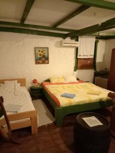 a bedroom with a bed and a chair in it at BUMBAR ETNO DVORAC in Tekija