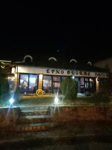 a building with a sign that reads boco divorce risk at night at BUMBAR ETNO DVORAC in Tekija