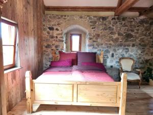 - une chambre avec un lit en bois dans un mur en pierre dans l'établissement Urlaub in der Burg am Bodensee, à Kressbronn am Bodensee