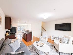 een woonkamer met een bank en een tafel bij Luxury & Stylish Townhome, King Beds, W/D, Garage in Schenectady