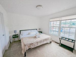 een witte slaapkamer met een bed en een raam bij Luxury & Stylish Townhome, King Beds, W/D, Garage in Schenectady