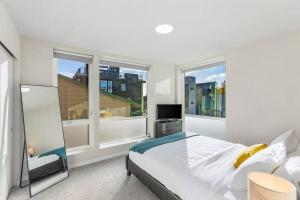 a bedroom with a bed and two large windows at Red Maple Retreat in Leschi in Seattle