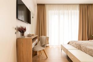 a bedroom with a bed and a desk and a chair at Casa mia Milano Malpensa in Gallarate