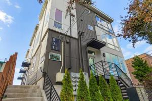 an apartment building with a clock on the side of it at Red Maple Retreat in Leschi in Seattle