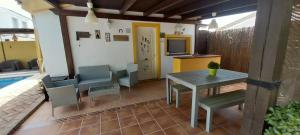 a patio with a table and chairs and a tv at Casa Victoria in Arcos de la Frontera