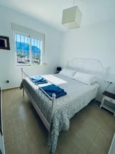 a bedroom with a bed with blue towels on it at Stunning mountain views! Private Villa with fabulous communal pool! in Murla