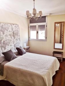 a bedroom with a bed and a window and a chandelier at Vista triangular in Las Palmas de Gran Canaria