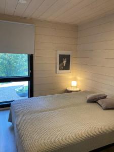 Un dormitorio con una cama grande y una ventana en Tammikon Tupa, en Tuusula