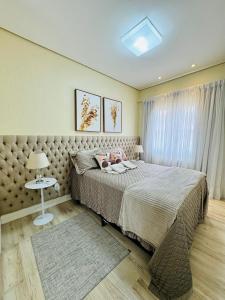 Un dormitorio con una cama grande y una ventana en MRG Luxo e Tranquilidade Casa de Pedra 2D, en Gramado