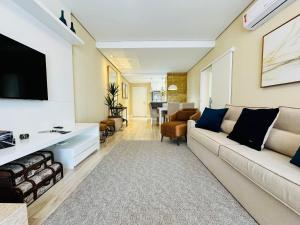 sala de estar con sofá y TV en MRG Luxo e Tranquilidade Casa de Pedra 2D, en Gramado