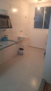 Baño blanco con lavabo y espejo en Apto 02 dormitórios emTatui, en Tatuí