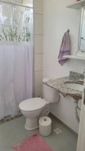 Baño blanco con aseo y lavamanos en Apto 02 dormitórios emTatui, en Tatuí
