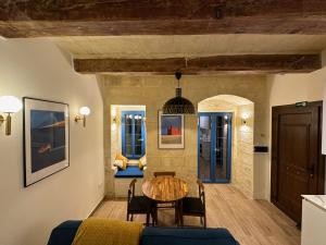 un soggiorno con tavolo e sedie in legno di Valletta Dome Apartment a La Valletta