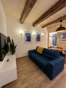 un soggiorno con un divano blu e un tavolo di Valletta Dome Apartment a La Valletta