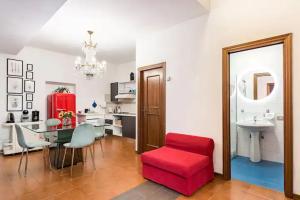 - un salon avec une chaise rouge et une table dans l'établissement Residenza degli Albizi, à Florence