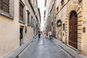 Un groupe de personnes marchant dans une rue dans l'établissement Residenza degli Albizi, à Florence