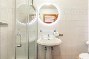 La salle de bains est pourvue d'un lavabo et d'une douche en verre. dans l'établissement Residenza degli Albizi, à Florence