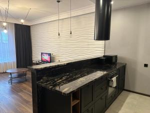 a kitchen with a large black counter top at Apartament Szarlotka in Łódź