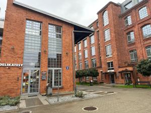 een groot bakstenen gebouw met een groot raam bij Apartament Szarlotka in Łódź