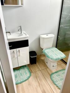 ein Badezimmer mit einem Waschbecken, einem WC und einem Spiegel in der Unterkunft Container Suítes Recanto Monte Trigo in São Francisco do Sul