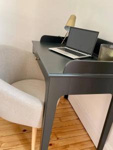 a desk with a laptop and a chair on it at T3 de charme au centre de Clermont in Clermont-Ferrand