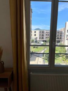 um quarto com uma janela com vista para um edifício em T3 de charme au centre de Clermont em Clermont-Ferrand