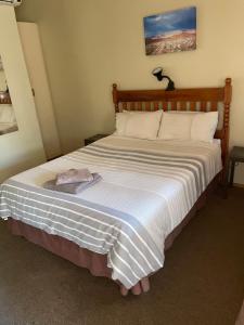 a bedroom with a large bed with a wooden headboard at Azalea BnB in Kuruman