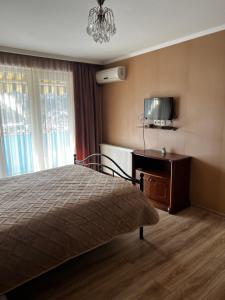 ein Schlafzimmer mit einem Bett und einem TV an der Wand in der Unterkunft Horizon Tbilisi in Tbilisi City