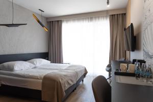 sypialnia z łóżkiem i dużym oknem w obiekcie Four Winds w mieście Krynica Morska