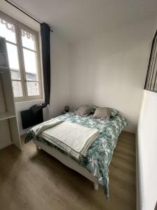 ein Schlafzimmer mit einem Bett in einem Zimmer mit einem Fenster in der Unterkunft Studio Design - Terrasse - Proche du stade in Saint-Étienne