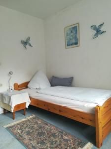 um quarto com uma cama de madeira e um banco em Gaestehaus jagsttalblick em Langenburg