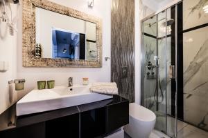 ein Bad mit einem Waschbecken und einem Spiegel in der Unterkunft Aparthotel Maargick in Krakau