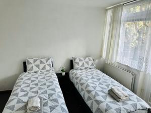 two beds sitting next to a window in a room at London City Apartment in London