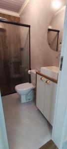 a bathroom with a toilet and a sink and a shower at Quarto privativo in Foz do Iguaçu