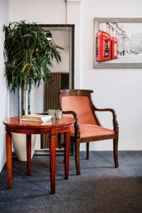 einen Tisch und einen Stuhl neben einem Couchtisch und einer Topfpflanze in der Unterkunft Aparthotel Maargick in Krakau