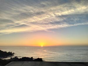 una puesta de sol sobre el océano con el sol en el cielo en B&B la spiaggetta di Stazzo, en Acireale