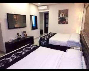 um quarto de hotel com duas camas e uma televisão em Salvatore Room With Breakfast-Tanta City em Tanta