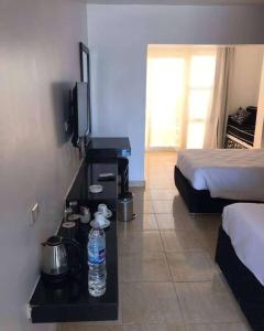a hotel room with a bed and a television and water bottle at Salvatore Room With Breakfast-Tanta City in Tanta