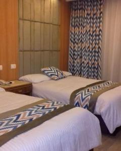 a hotel room with three beds and a window at Salvatore Room With Breakfast-Tanta City in Tanta