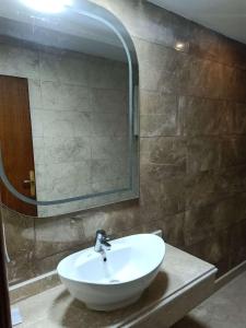 een badkamer met een witte wastafel en een spiegel bij Salvatore Room With Breakfast-Tanta City in Tanta