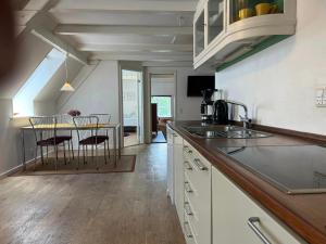 a kitchen with a counter and a table with chairs at Skovridergaardens Ferielejligheder in Aabenraa