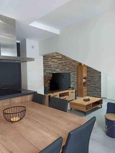 un salon avec une table en bois et une télévision dans l'établissement Magnifique T3 Terrasse, Parking!, aux Rousses