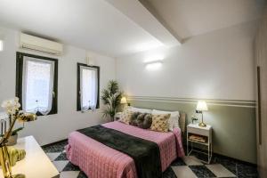 a bedroom with a bed with a pink blanket at Secret Garden - Villafranca di Verona centro in Villafranca di Verona