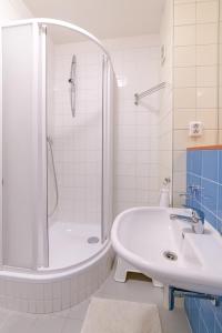 Baño blanco con bañera y lavamanos en Strawberry Apartment, en Bratislava
