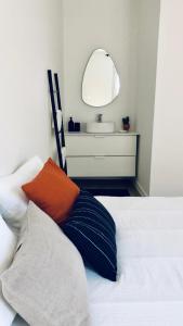 1 dormitorio con cama con espejo y lavamanos en Appartement Coeur de Ville Cathédrale - Ascenseur -, en Colmar