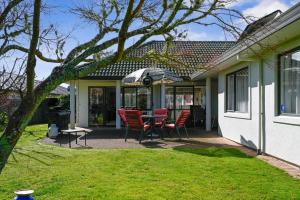 a house with a patio with chairs and a table at Bootten's Hut in Rotorua