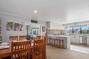 a dining room and kitchen with a table and chairs at Bootten's Hut in Rotorua