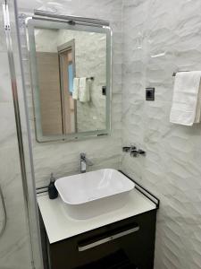 a bathroom with a white sink and a mirror at Apartment Stella in Mali Lošinj