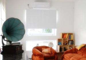 een woonkamer met 2 stoelen en een spiegel bij The Cosy Nest in Pignataro Maggiore